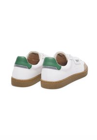 Sneaker in pelle bianca con dettagli in suede beige sul puntale e una suola in gomma. Fascetta verde sulla parte posteriore e fori decorativi sui lati.