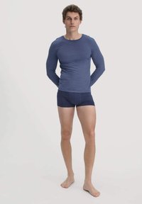Marineblauwe longsleeve-shirt met een ronde halslijn en een aansluitende pasvorm, gecombineerd met marineblauwe boxershorts. Gladde textuur, eenvoudig en minimalistisch ontwerp.