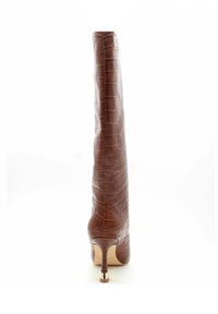 Stivale in pelle marrone fino al ginocchio con texture coccodrillo, silhouette snella, punta affusolata e alto tacco a stiletto con finiture metalliche.