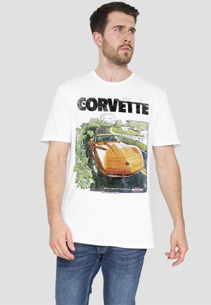 White t-shirt featuring a graphic of an orange Corvette on a scenic road, with black text reading "Corvette" above the illustration.