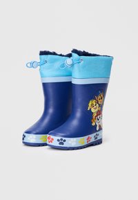 Botas de lluvia de goma en azul marino con un puño superior de color azul claro. Presentan un diseño de dibujos animados en el lateral y una suela decorada con huellas de patas de colores.