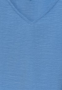 T-shirt blu in cotone con scollo a V, realizzato in un tessuto leggero e testurizzato. Presenta un sottile motivo melange e cuciture rinforzate lungo il colletto.