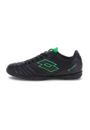 Zapatilla deportiva negra con logo y detalles verdes, diseño con cordones y suela plana para uso en interiores o césped artificial.