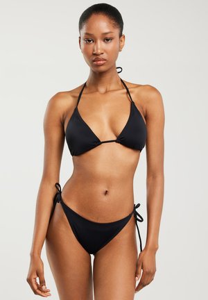 Czarny bikini wykonane z gładkiego materiału; posiada trójkątny stanik z cienkimi ramiączkami oraz regulowane majtki z wiązaniem po bokach. Minimalistyczny design bez wzorów.