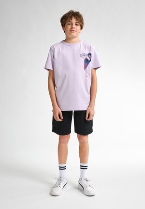 Lila katoen t-shirt met een flamingo-graphic op de borst, gecombineerd met zwarte cargoshorts, witte sneakers en gestreepte enkelsokken.