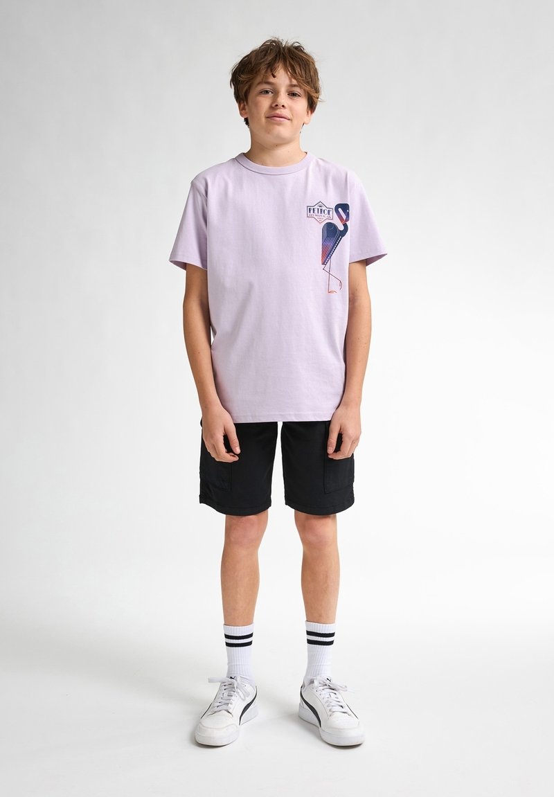 Lyserød bomulds-t-shirt med en flamingo-grafik på brystet, parret med sorte cargoshorts, hvide sneakers og stribede ankelstrømper.