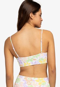 Bralet s kvetinovým potlačou v pastelových farbách s tenkými nastaviteľnými ramienkami, s jednoduchým zapínaním na chrbte. Mäkko, ľahký materiál.