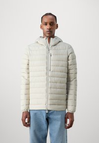 Jachetă puf gri deschis cu design cu quilturi orizontale, glugă, fermoar frontal și un buzunar pe pieptul stâng; asortată cu blugi din denim albastru.