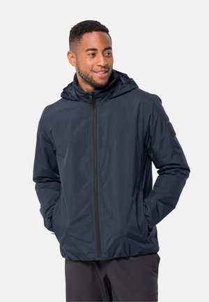 Veste légère bleu marine avec capuche, fermeture éclair, deux poches avant et tissu texturé. Comprend un patch logo sur la manche.