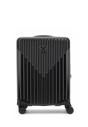 Valise rigide noire avec des rainures verticales, quatre roulettes pivotantes et un logo triangulaire Guess en haut au centre.