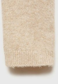 Manche en laine beige tricotée avec bord-côte, montrant une texture douce et duveteuse ainsi qu’un gros plan du motif tricoté du tissu.