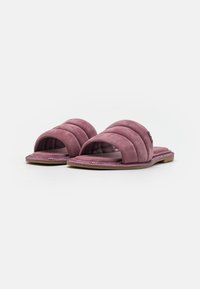 Lila mockaskinnsandaler med vadderad design och tre horisontella ränder, öppen tå och en platt, strukturerad sula.