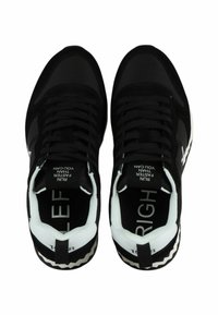 Sneaker nere con una toma in tessuto testurizzato, punta rigonda, dettagli bianchi e parole stampate "SINISTRO" e "DESTRA" sulle suole interne.