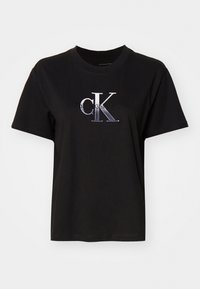 Černé bavlněné tričko s krátkým rukávem, s vyšitým stříbrným logem "cK" a textem "Calvin Klein Jeans" pod ním. Jednoduchý, neformální design.