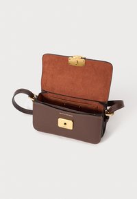 Brown leather bag with a suede interior, gold hardware, and a magnetic closure. Features a detachable strap and multiple card slots.