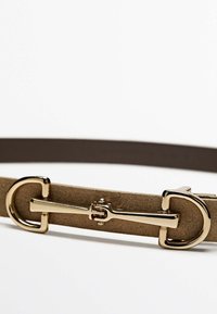 Cintura in suede marrone con una fibbia in metallo dorato lucido caratterizzata da un design a doppio cerchio e una barra centrale. Texture liscia in tutto il suo insieme.