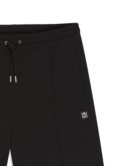 Pantalon de jogging noir à cordon avec poches latérales et une petite écusson carré "HUGO" sur la cuisse droite.