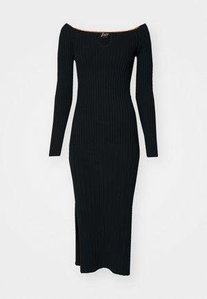 Zwarte geribbelde gebreide jurk met off-shoulder halslijn, lange mouwen en een zijspleet. Bevat een keyhole uitsnijding en een oranje accent bij de kraag.