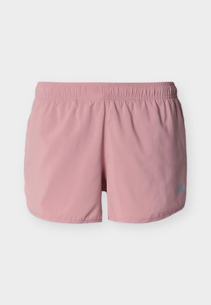 Shorts de sport rose clair avec ceinture élastique et petit logo réfléchissant sur la partie inférieure de la jambe droite, présentés sur un fond blanc.
