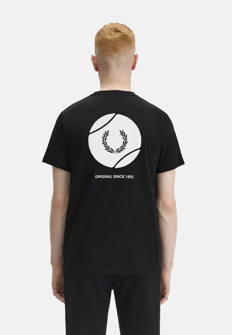 T-shirt in cotone nero con una grafica circolare bianca che presenta una corona di alloro e il testo "ORIGINAL SINCE 1952" sul retro. Maniche corte.