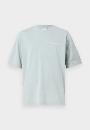 Gaiši zila kokvilnas T-kreklu ar īsām piedurknēm un apaļu izgriezumu. Uz krūtīm ir neliels balts logotipa teksts.