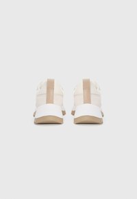Sneakers beige con tomaia liscia, suola intermedia bianca e suola esterna marrone chiaro. Presentano un retro dritto, un design minimal e nessun motivo visibile.