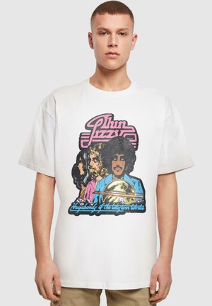 Hvid bomulds t-shirt med farverigt grafisk print af tre figurer med fede konturer og teksten "Thin Lizzy" i pink. Korte ærmer, afslappet pasform.