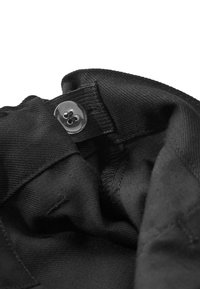 Intérieur en tissu noir avec une texture lisse, comportant un bouton en plastique transparent et un bord surpiqué. Le design inclut une fermeture cachée.