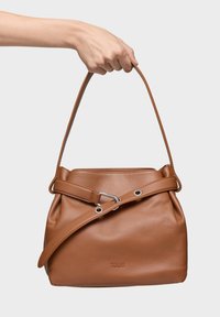 Brązowa skórzana torba typu bucket z pojedynczym uchwytem i regulowanym paskiem. Gładka tekstura, metalowe okucia i tłoczone logo.
