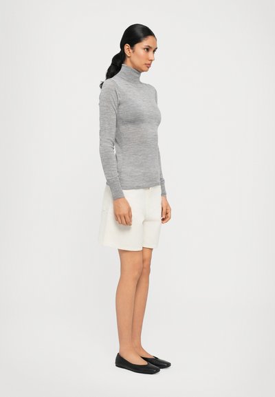 Light gray fitted turtleneck sweater, white shorts, and black flats. The sweater has a smooth texture; the shorts are tailored with a simple design.