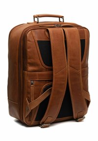 Zaino in pelle marrone con forma rettangolare, spallacci imbottiti, dettagli in rete e numerosi scomparti con zip per lo stoccaggio.