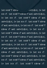 Hoodie marine avec un texte blanc répété qui dit "Elle ne savait pas que c'était impossible, alors elle l'a fait." Le texte est en gras avec un style manuscrit.
