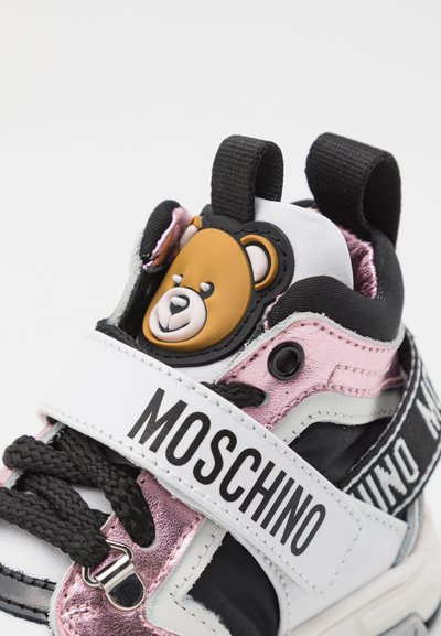Barnes sneakers med svarte snører og rosa, svarte og hvite detaljer, med motiv av et teddy-bjørn ansikt og "MOSCHINO" merkevaren på stroppen.
