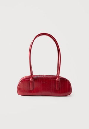 Μικρή κόκκινη δερμάτινη τσάντα με μακριές στρογγυλεμένες λαβές και διακριτικό υφασμάτινο μοτίβο, τοποθετημένη σε απλό φωτεινό φόντο.
