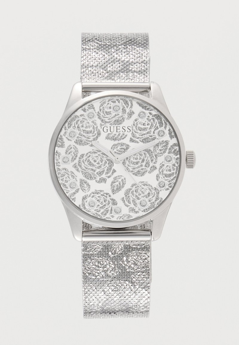 Ασημένιο ρολόι Guess με floral σχέδιο στο καντράν και μπρασελέ από σίτα, μίνιμαλ σχεδιασμός, χωρίς αριθμούς, εμφανείς δείκτες ώρας και λεπτών.