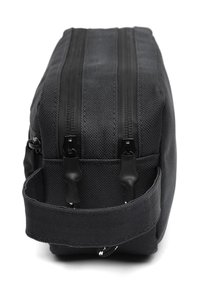 Black fabric toiletry bag with two zippered compartments, flat shape, reinforced stitching, and a side handle for easy carrying.