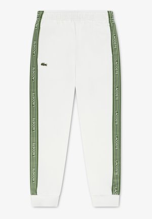 Bele trenirke z zelenimi stranskimi črtami in napisom "LACOSTE", elastičen pas in manšete, narejene iz gladkega, mehke tkanine.