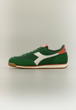 Green and orange athletic shoe with white logo, mesh and suede texture, brown sole, and lace-up front, shown from the side.
