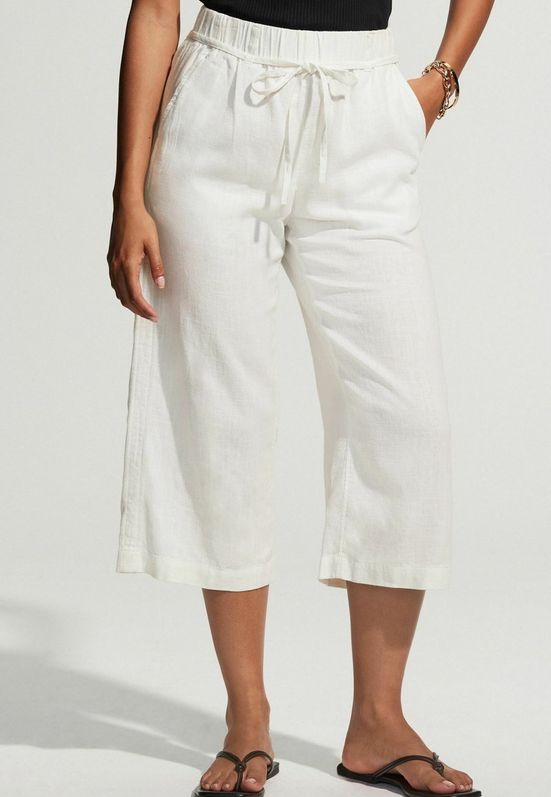 Fehér vászon cropped nadrág, rugalmas derékkal és húzózsinórral, sima felülettel és széles lábakkal.