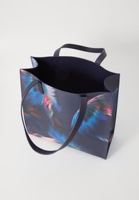 Grandi borse tote in similpelle blu navy con motivo di piume colorate. Presenta due manici robusti e un logo del marchio impresso sul davanti.