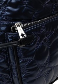 Borsa trapuntata blu navy con motivo a stella, dotata di un comparto con cerniera e hardware in tono argento con un tirazip a forma di stella.