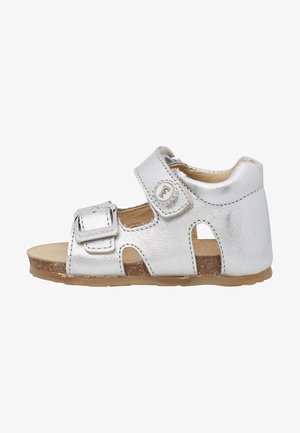 Sandale en cuir argenté avec un bout fermé et des côtés ouverts. Dispose d'une sangle ajustable avec une boucle métallique et d'une semelle texturée.