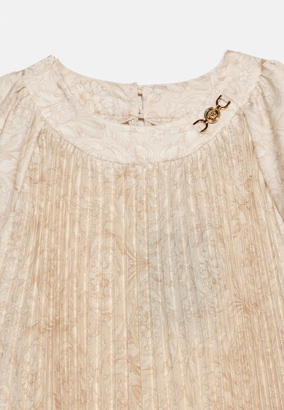 Κρεμ πλισέ φόρεμα με φλοράλ σχέδιο, φουσκωτά μανίκια και διακοσμητικό χρυσό καρφίτσα κοντά στη λαιμόκοψη.