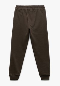 Bruine sweatpants van zachte stof, met een elastische tailleband en geribde boorden bij de enkels. Glad materiaal met een ontspannen pasvorm.