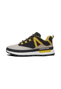 Grijze en zwarte sneaker met gele accenten. Heeft een bovenwerk van mesh, een gevoerde zool en een karakteristieke "TIMBERLAND" branding aan de zijkant.