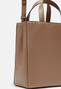 Tote-Bag aus tanfarbenem Leder mit strukturierter, rechteckiger Form. Verfügt über kurze Oberhandgriffe und einen abnehmbaren Schultergurt. Glatte Textur.