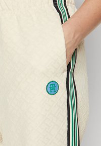 Tommy Hilfiger TAPE RELAXED - Tracksuit bottoms - calico