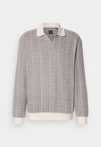 Long-sleeve knit polo sweater with textured brown and white pattern, cream collar, and cream ribbed cuffs and hem.