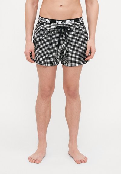 Kąpielówki w czarno-białą kratkę w stylu gingham z elastycznym paskiem w talii, sznurkiem i detalem z logo. Materiał jest lekki i oddychający.