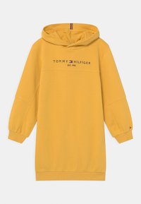 Żółta sukienka z kapturem o luźnym kroju, z przodem z logo "TOMMY HILFIGER EST. 1985" oraz ściągaczami z kontrastującymi kolorami.